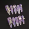 Lavender marble press-on nails with butterfly and bow charms – full hand view