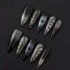 Long black press-on nails with shimmer gradient and butterfly charm – frontal view