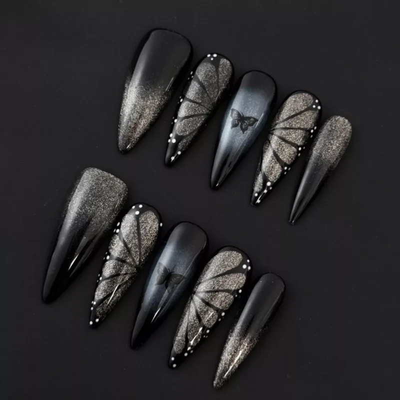 Long black press-on nails with shimmer gradient and butterfly charm – frontal view