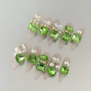 long press-on nails with emerald green heart gems and pearl accents