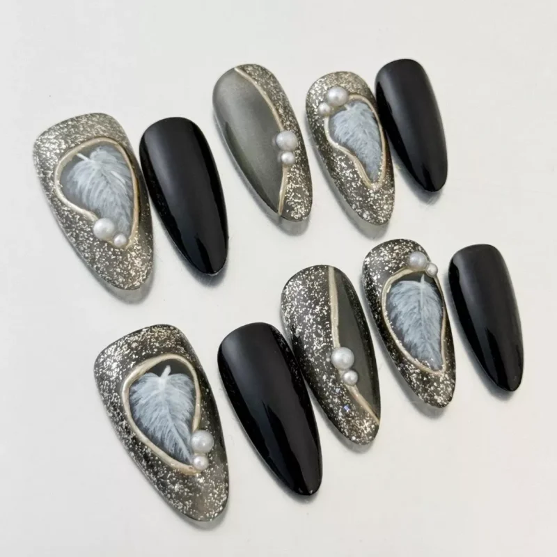 Close-up of Black Glitter Press-On Nails with 3D pearl and feather charms