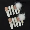 Luxury bow and butterfly press-on nails with pom-pom accents and nude white contrast