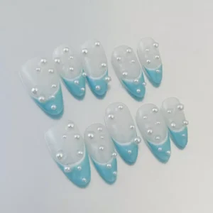 Close-up of 3D pearl detailing on matte blue oval press-on nails