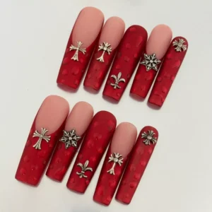 Matte red press-on nails with 3D texture and silver cross charms