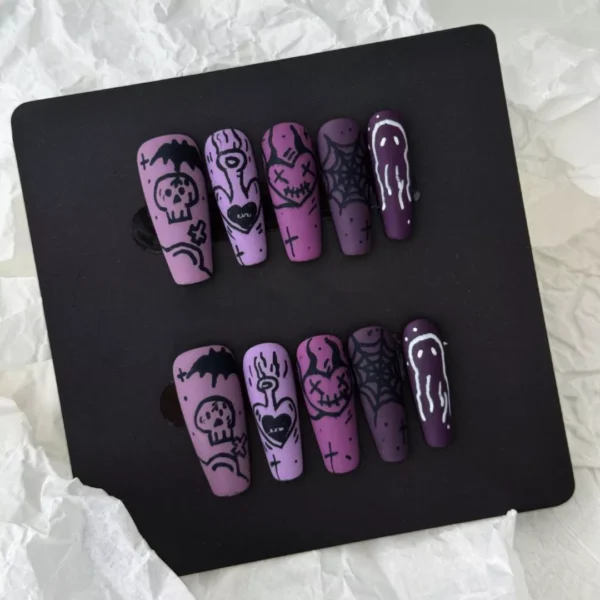 Spread of matte purple press-on nails with dripping tips and spooky Halloween art for women