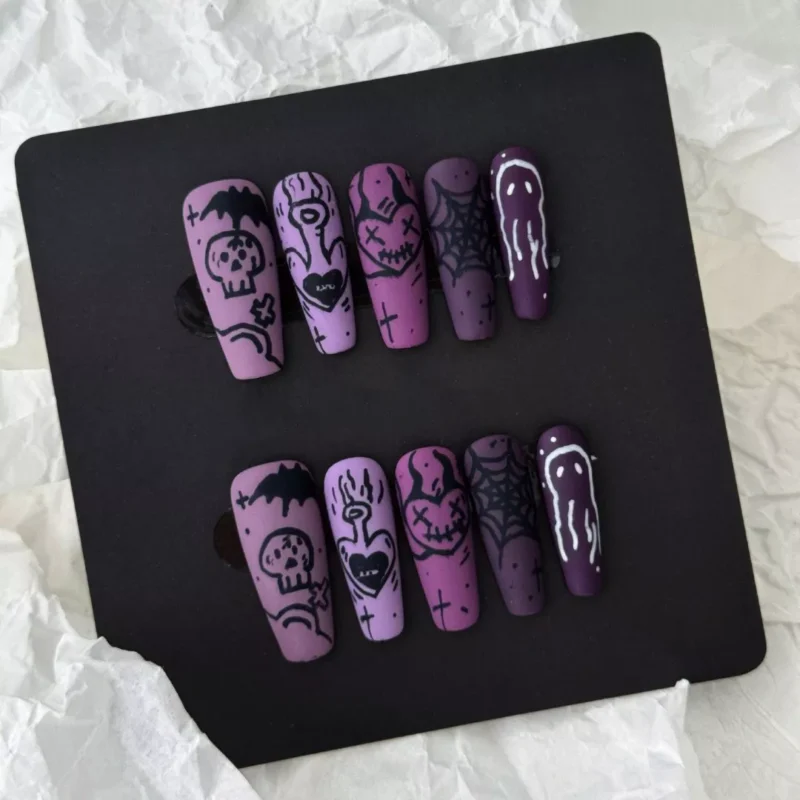 Spread of matte purple press-on nails with dripping tips and spooky Halloween art for women