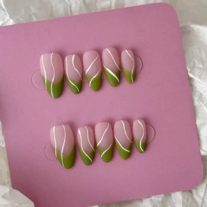 Minimalist nude green nails in almond shape with matte surface and white artistic lines