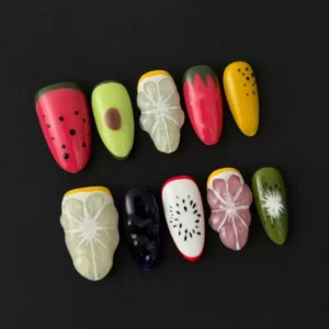 Side angle of mixed fruit press-on nails showing 3D kiwi and citrus elements