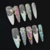 Mixed pastel press-on nails featuring 3D flower and butterfly accents with gold bead details – top view