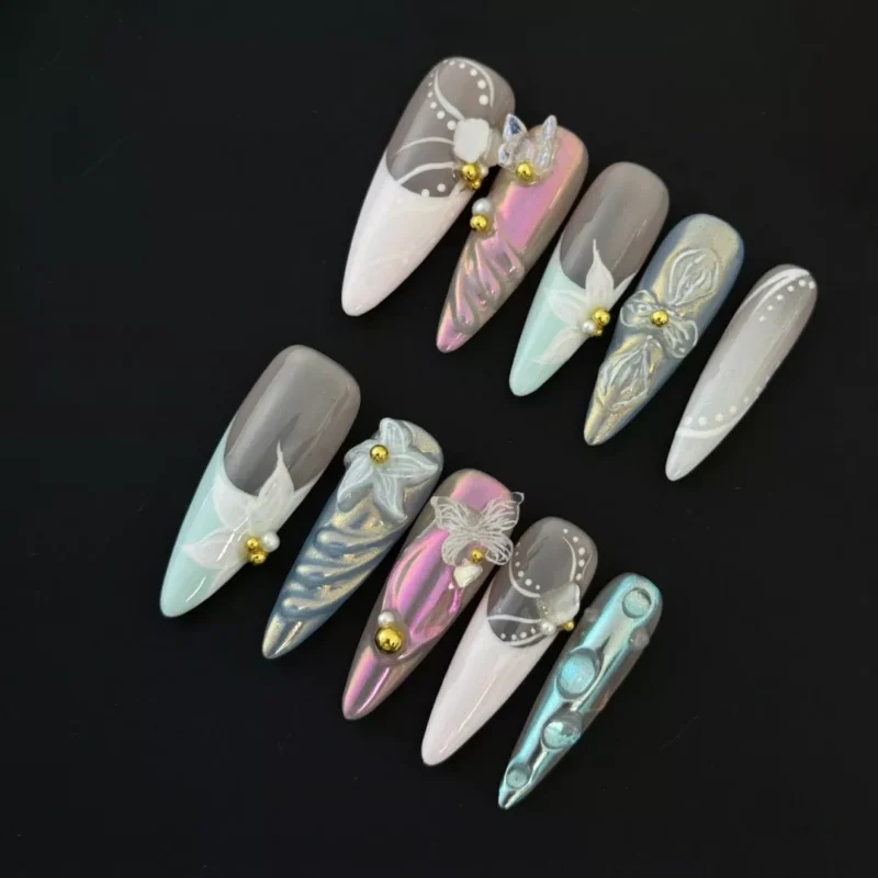 Long almond press-on nails in soft pink, lilac, and mint with floral 3D textures and gold beads