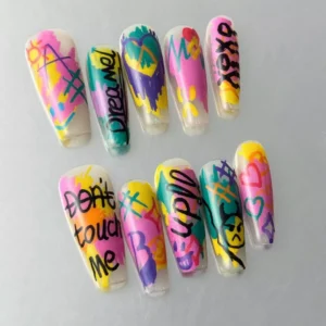 Close-up of hand-drawn letter nail art with colorful neon street tag graphics