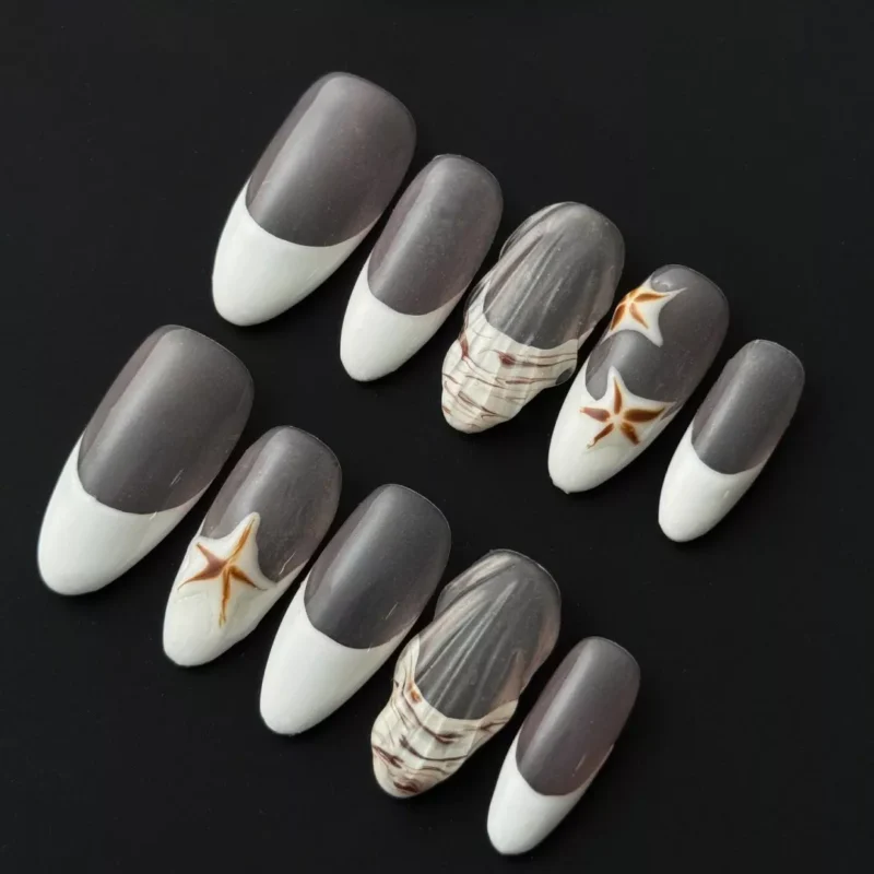Neutral French press-on nails with white tips, featuring 3D shell textures and starfish motifs – full hand view