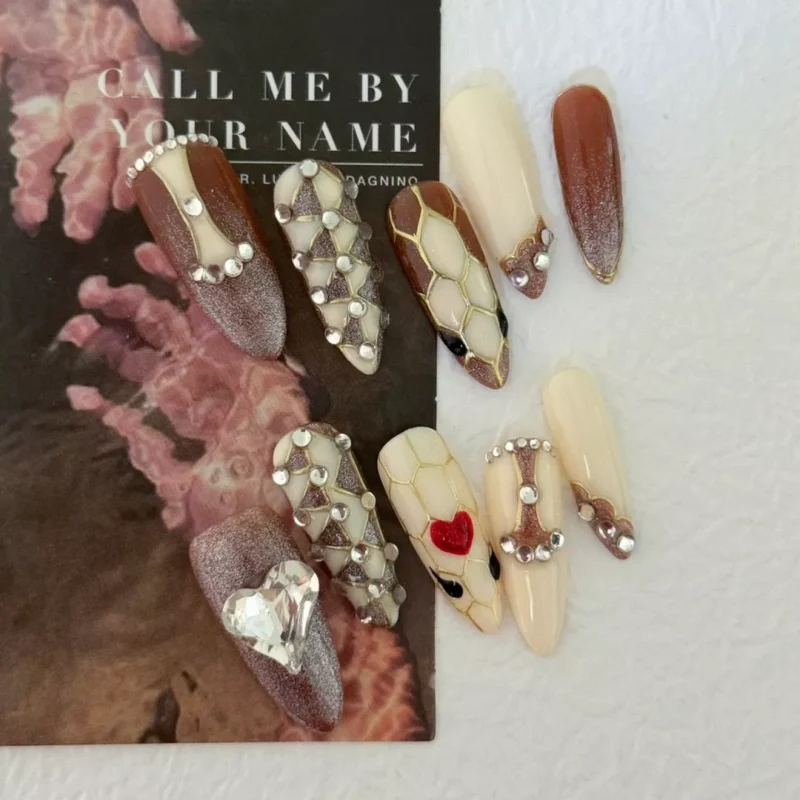 Brown nude press-on nails with honeycomb pattern and bold heart-shaped rhinestone