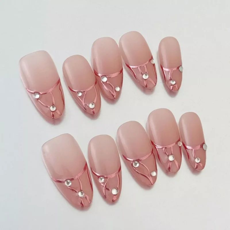 Nude coffin press-on nails featuring rose gold line design and small rhinestones – close-up detail