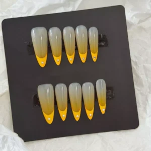 French ombre nails in yellow on sheer base with pointed almond shape – top view