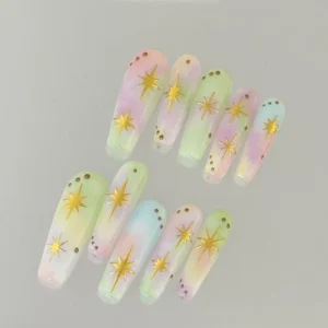 Pastel Ombre Press-On Nails decorated with gold stars, flat lay view
