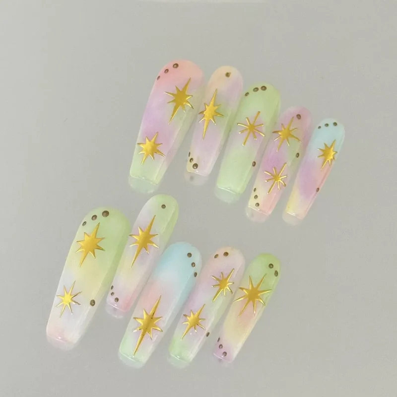 Pastel Ombre Press-On Nails decorated with gold stars, flat lay view