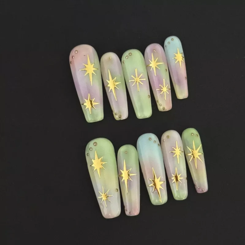 Pastel Gradient Press-On Nails with golden star charms on black background