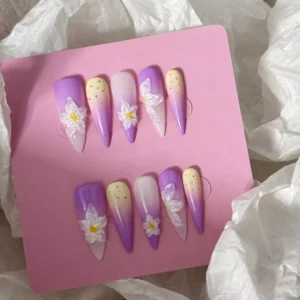 Set of purple ombre press-on nails with 3D flower accents on pink card