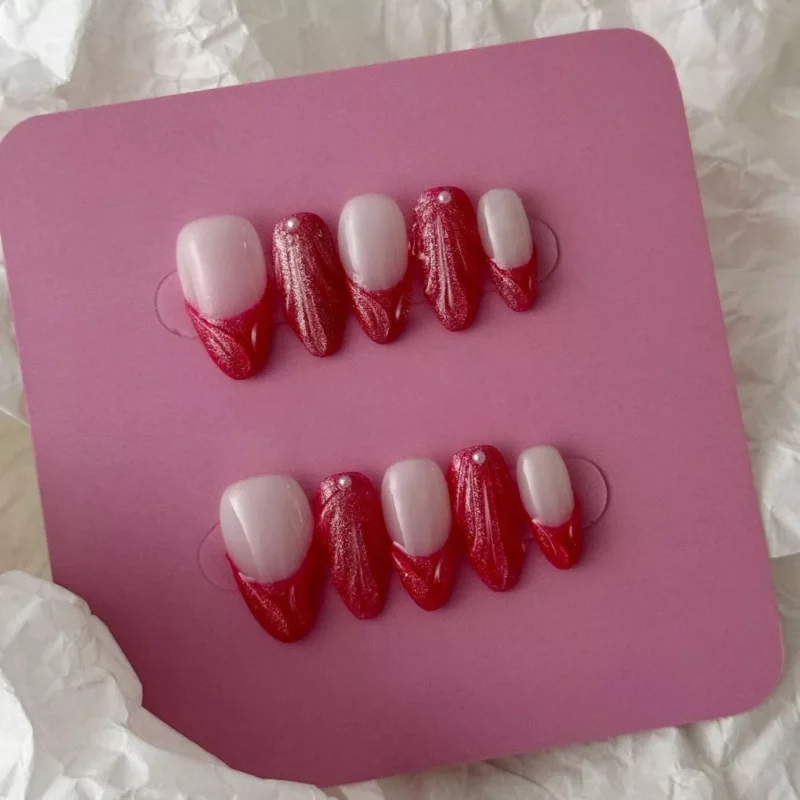 French tip red press-on nails with shimmering pearl and sculpted matte surface