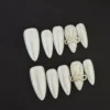 Pearl White Press-On Nails with 3D bow and pearl accents on black background
