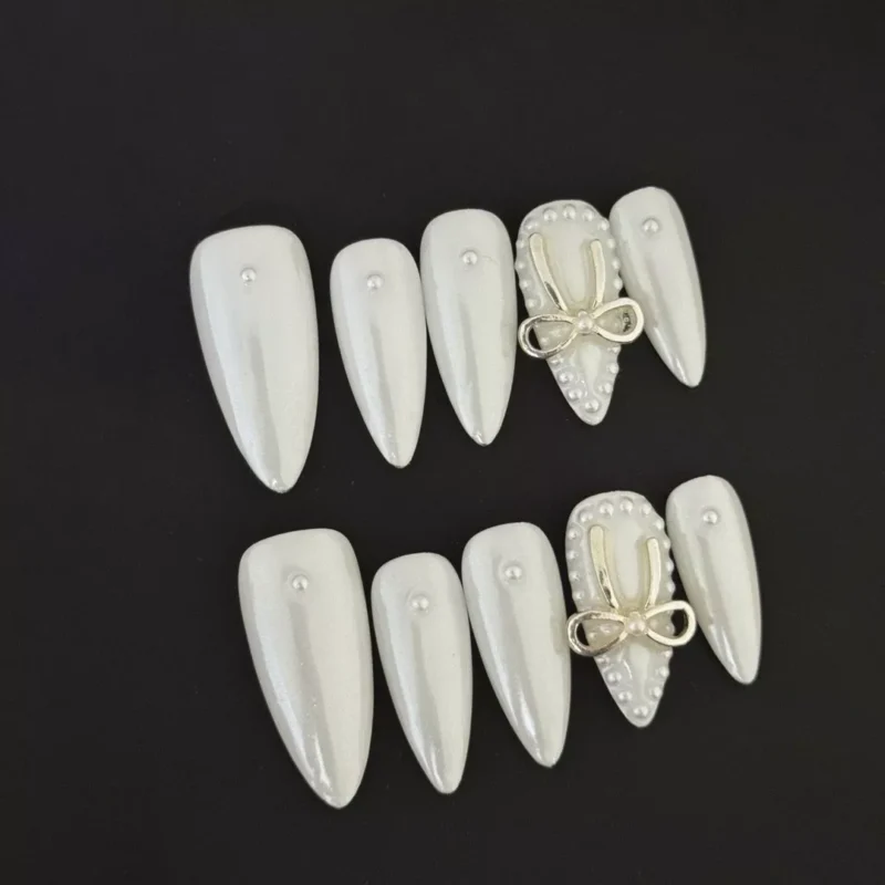 Pearl White Press-On Nails with 3D bow and pearl accents on black background
