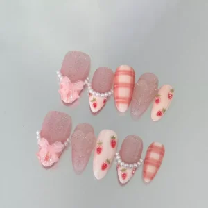 Pink glitter and strawberry press-on nails with heart and pearl accents
