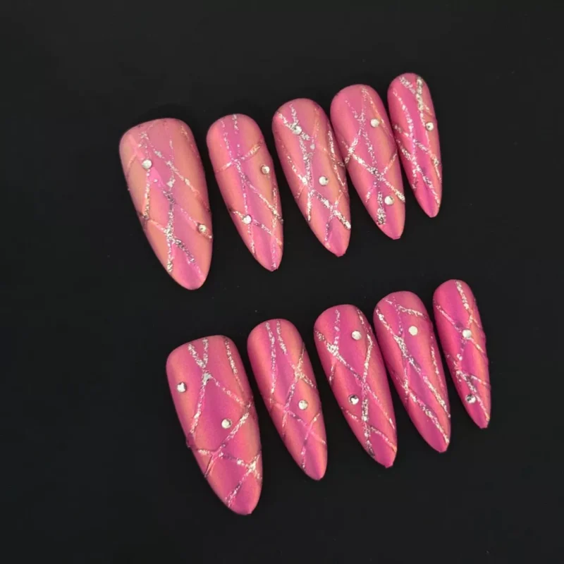 Pink Ombre Glitter Press-On Nails with diamond accents on a black background