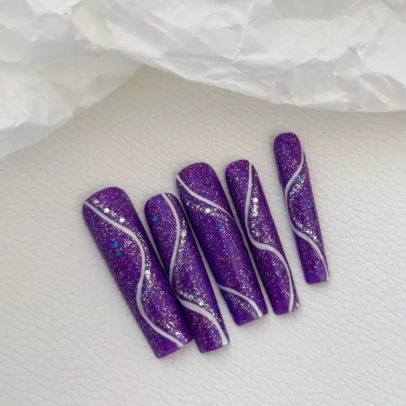 Detailed view of purple glitter press-on nails with elegant silver wavy lines