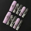 Purple gothic press-on nails with zebra stripes and silver cross charm – top view
