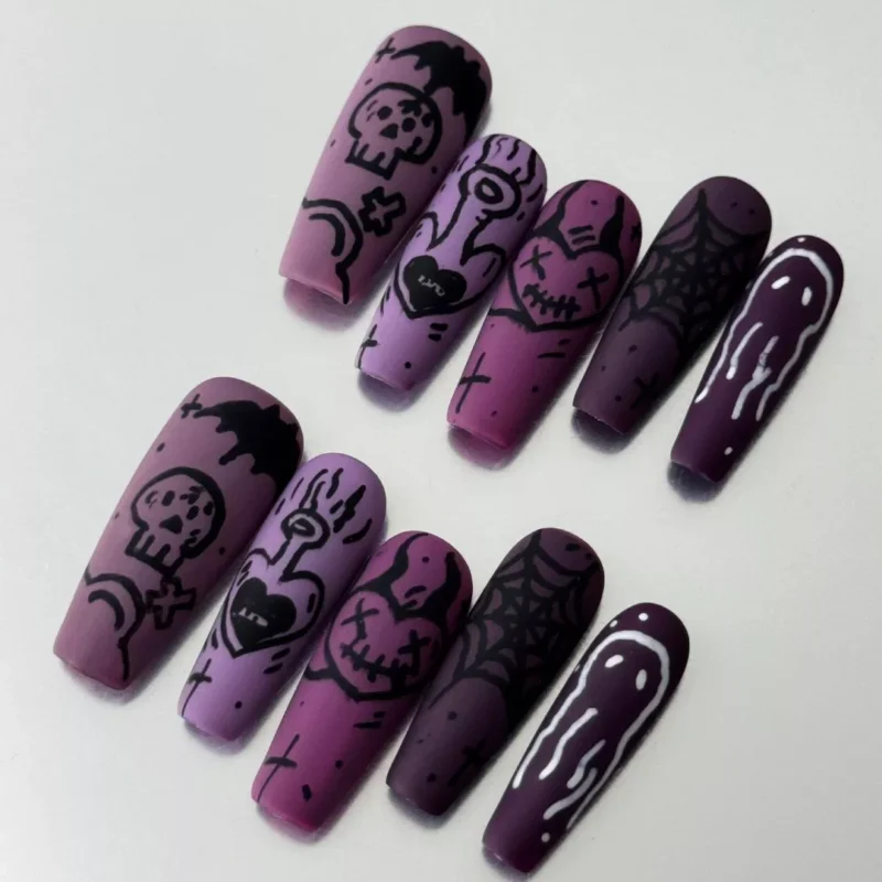 Close-up of purple gradient stiletto nails with hand-drawn stitched heart and ghost illustrations
