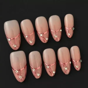 Elegant rose gold nails with rhinestone details and soft nude base – side perspective