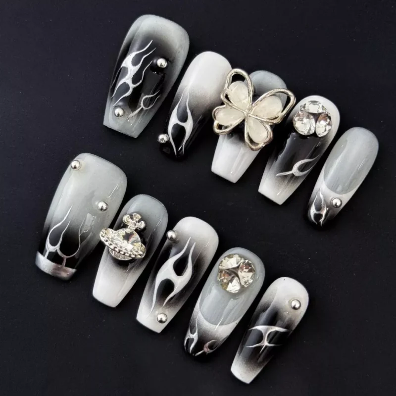 Rhinestone Flame Nails with 3D charm detail over black ombre background – detail shot