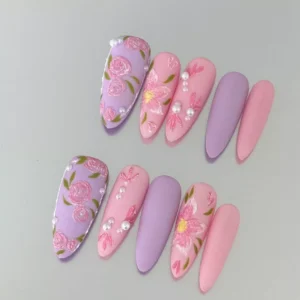 Romantic matte pink and lilac press-on nails featuring embroidery-style floral carvings