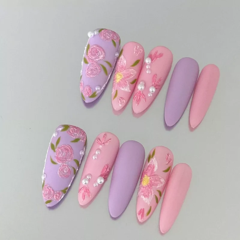 Romantic matte pink and lilac press-on nails featuring embroidery-style floral carvings