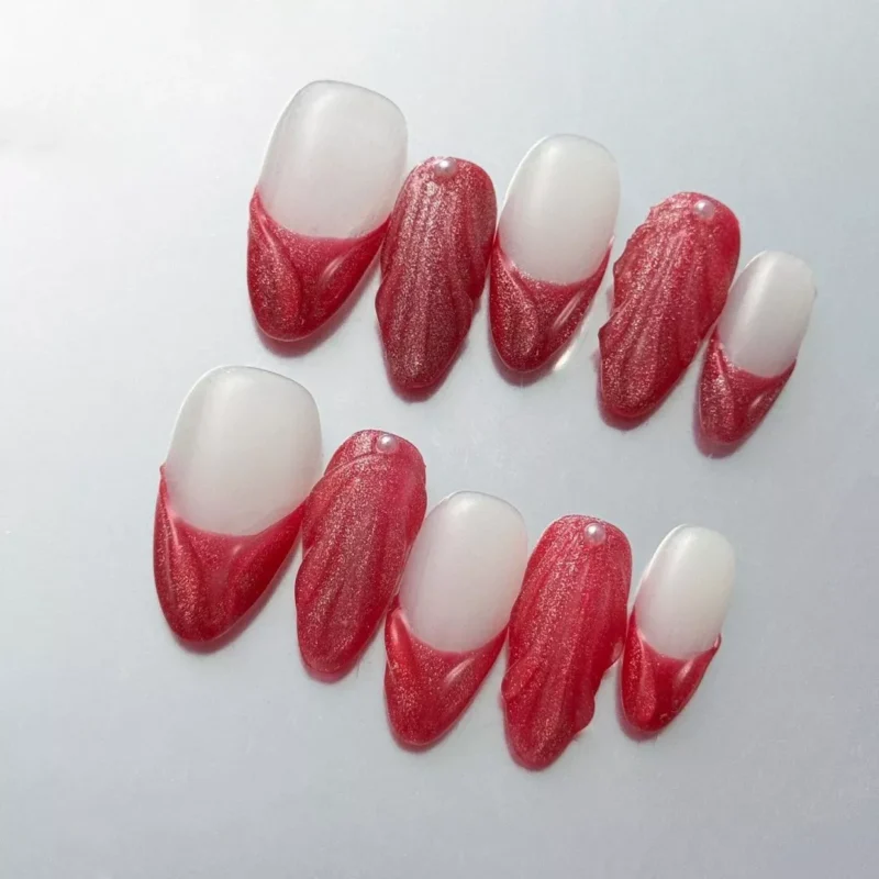 Matte red almond nails with pearl sculpted accents in elegant French style