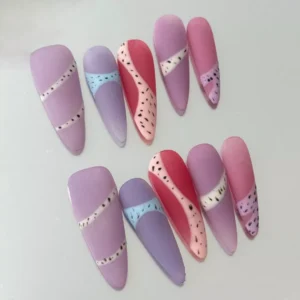 Close-up of pastel matte nail with dotted accent and almond shape