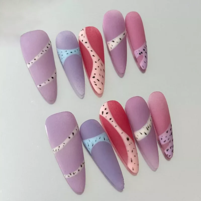 Close-up of pastel matte nail with dotted accent and almond shape