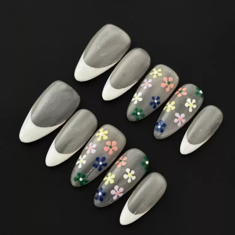 Sheer French tip press-on nails with multicolor 3D floral accents on nude base