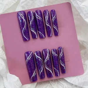 Purple glitter press-on nails with silver accents and wavy design