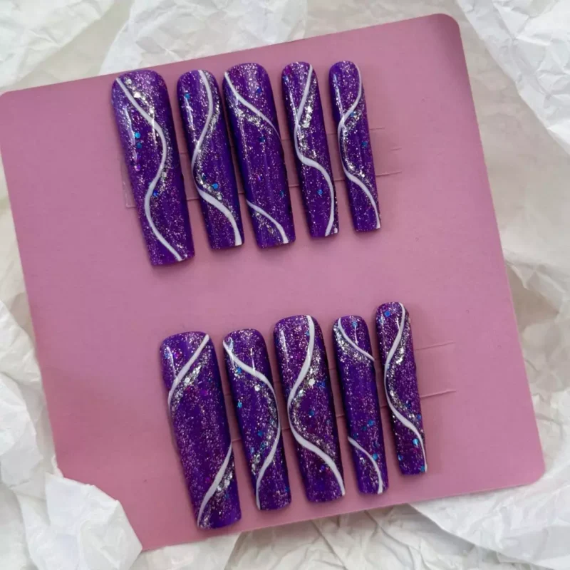 Purple glitter press-on nails with silver accents and wavy design