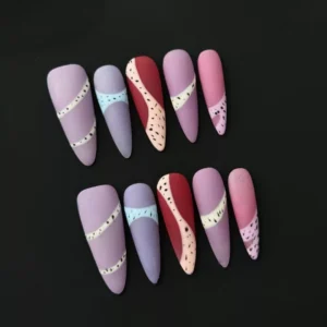 Matte almond press-on nails with pastel patchwork and sesame dot details – front view