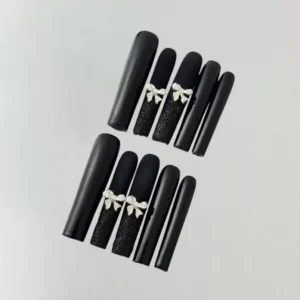 Side angle of black press-on nails with silver bows and matte gloss combination