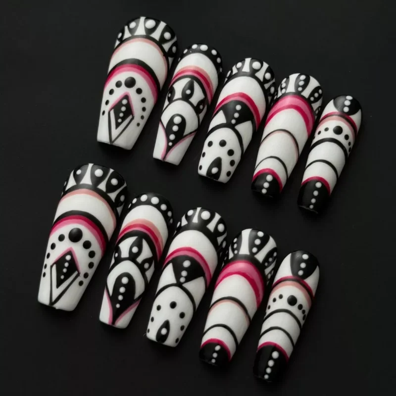 Side view of stiletto press-on nails with ethnic pattern and black, white, and red contrast