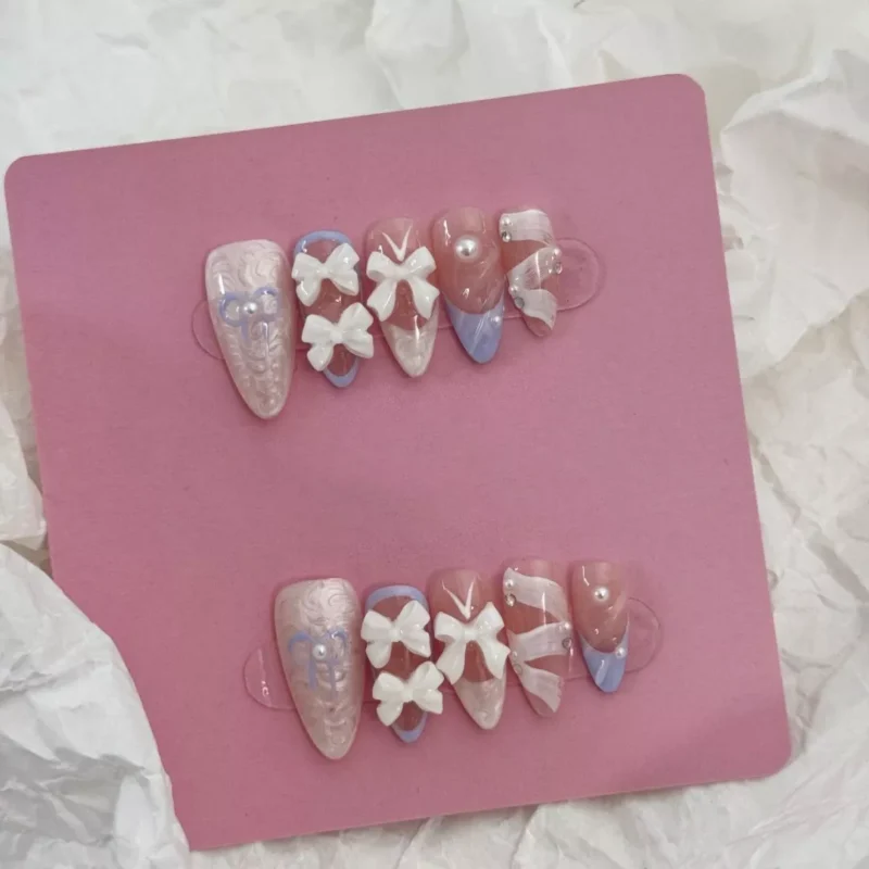 Side angle view of White Bow Press-On Nails highlighting glossy finish and pearl accents