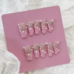 Side angle view of Pink Pearl Press-On Nails with glossy finish and pearl accents
