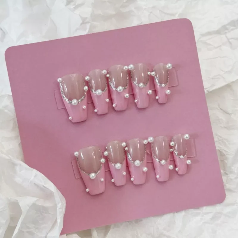 Side angle view of Pink Pearl Press-On Nails with glossy finish and pearl accents