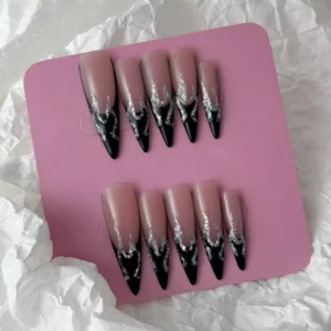Silver flame press-on nails with black French tip – flat lay on soft fabric