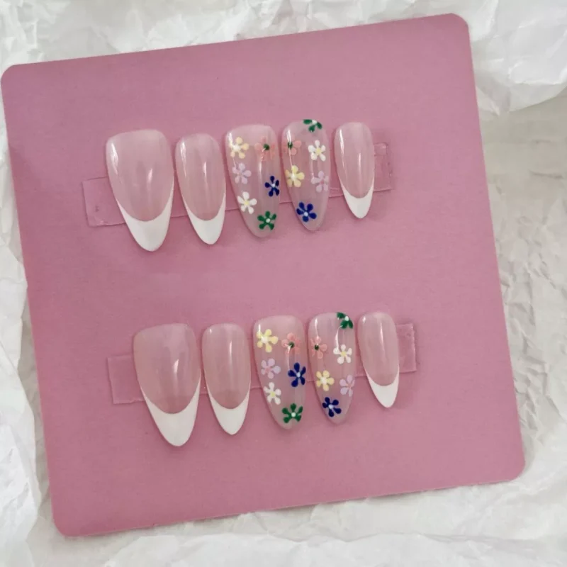 Spring-inspired pastel press-on nails with sheer base and dainty flower charms