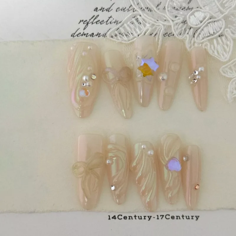 Close-up of bridal stiletto nails with aurora shimmer and gem embellishments